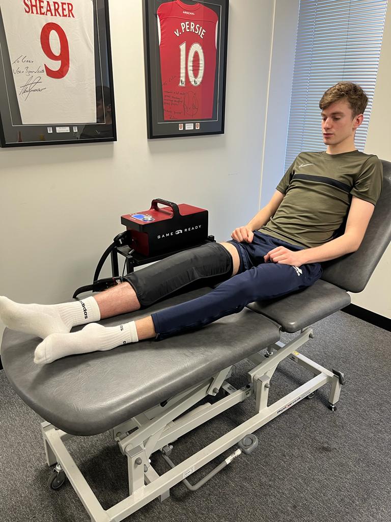 male patient on bed with knee support knee injury